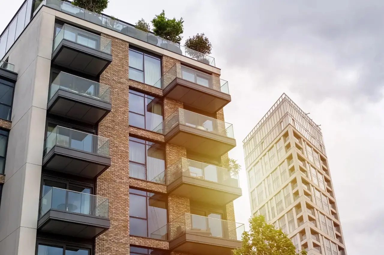 Modern apartment building with balconies and sunlight.