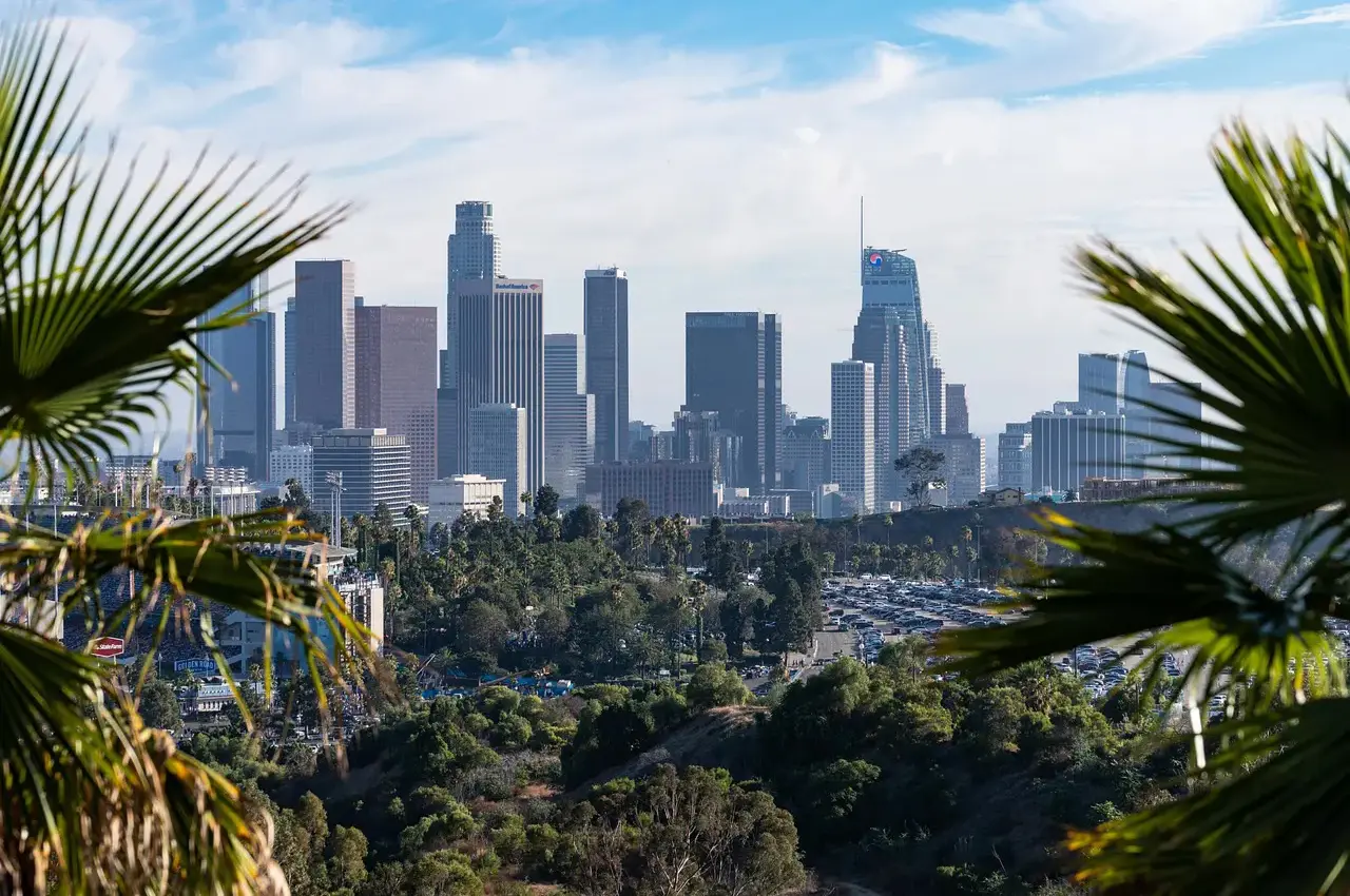 City skyline with tall buildings under a partly cloudy sky.