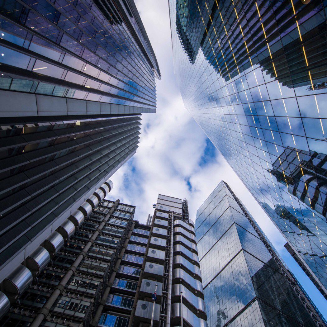 Skyscrapers viewed from below against cloudy sky.