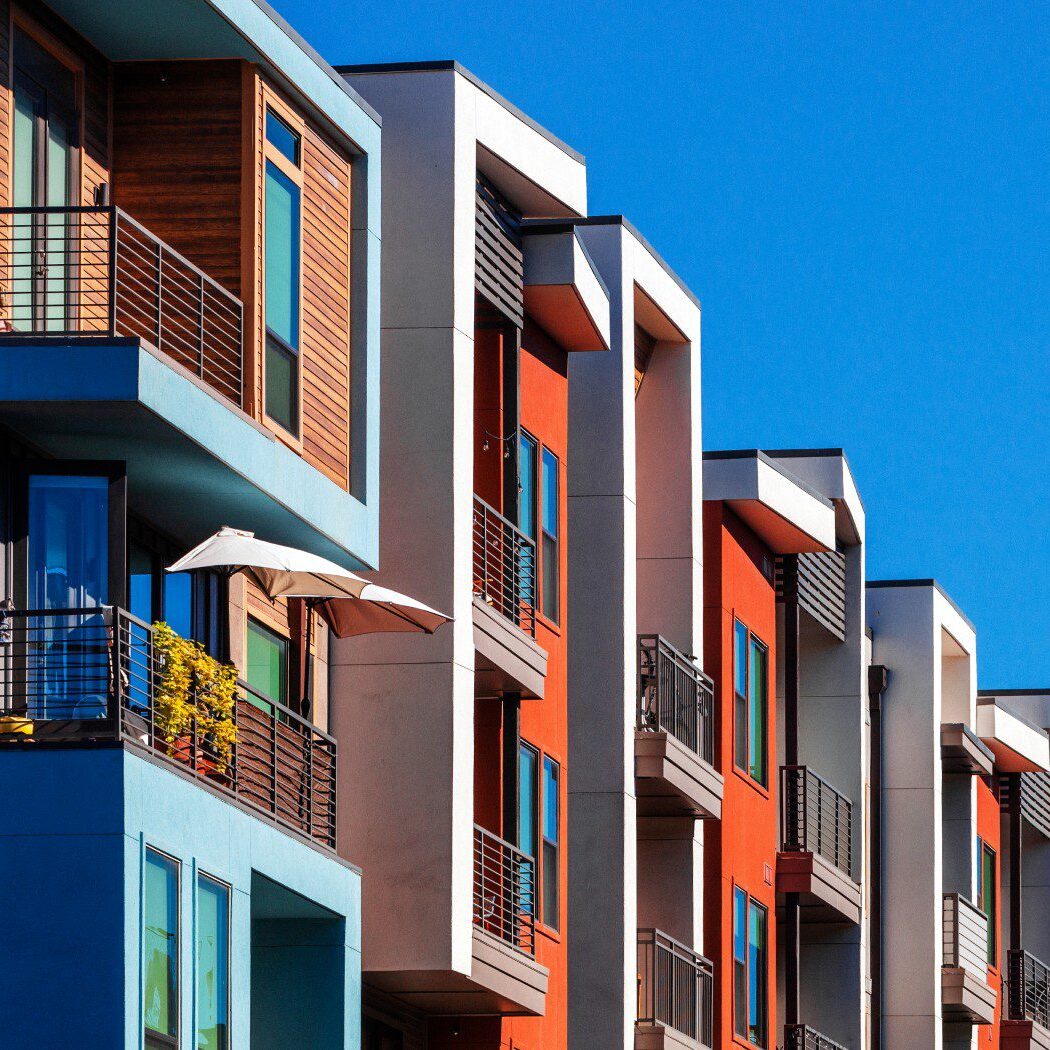 Modern colorful apartment buildings under blue sky.