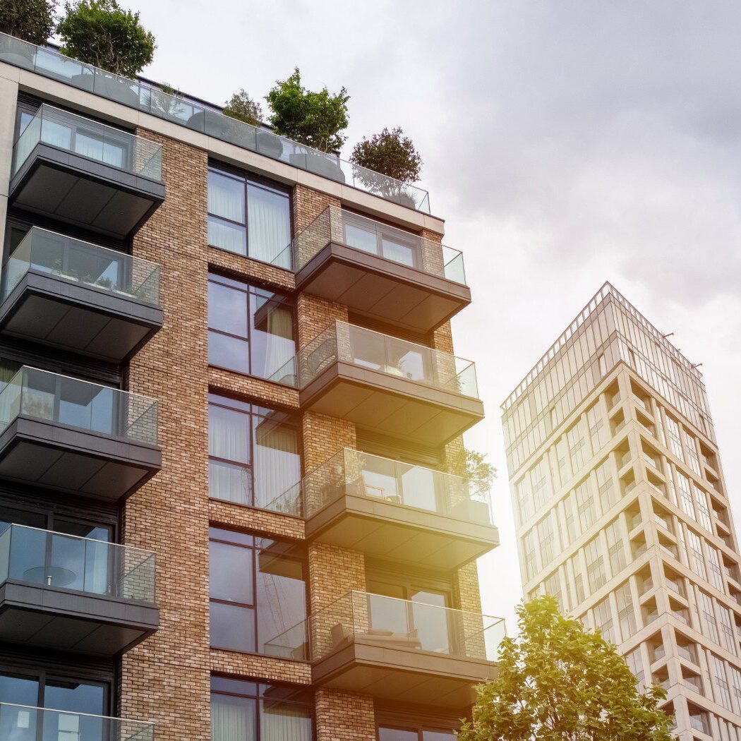 Modern apartment buildings with balconies and trees.
